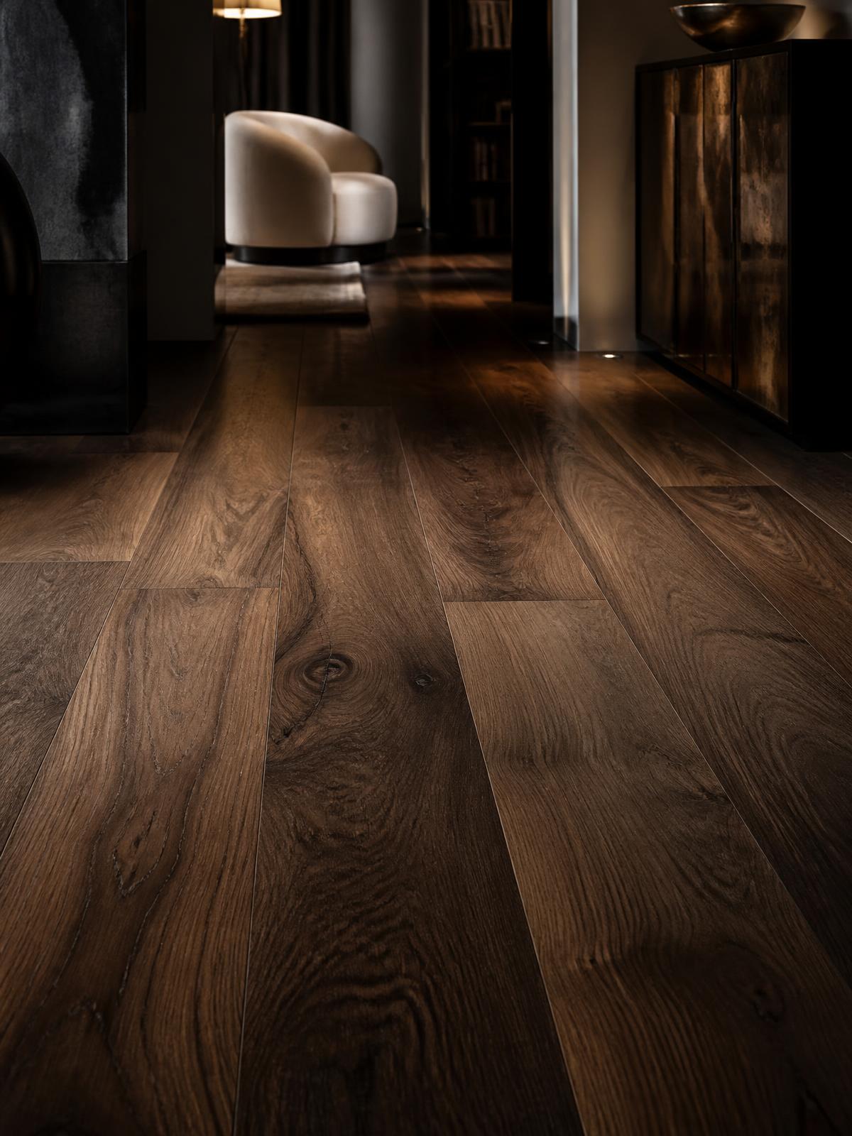 Wide-plank walnut flooring in a moody, luxurious interior